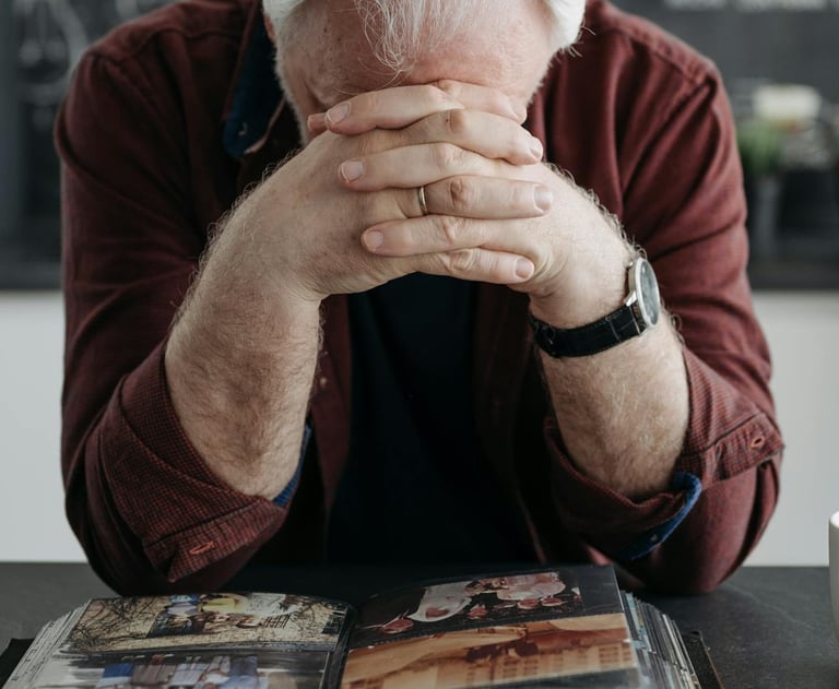a man with elbows on table and head down