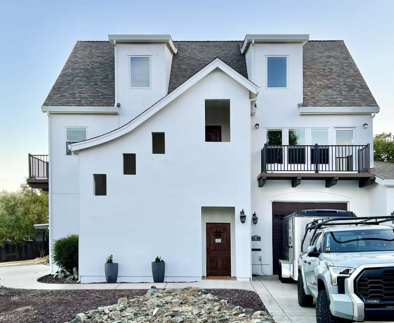 A French Revival architecture home with sloping roof lines, high dormers, and cantilevered decks.
