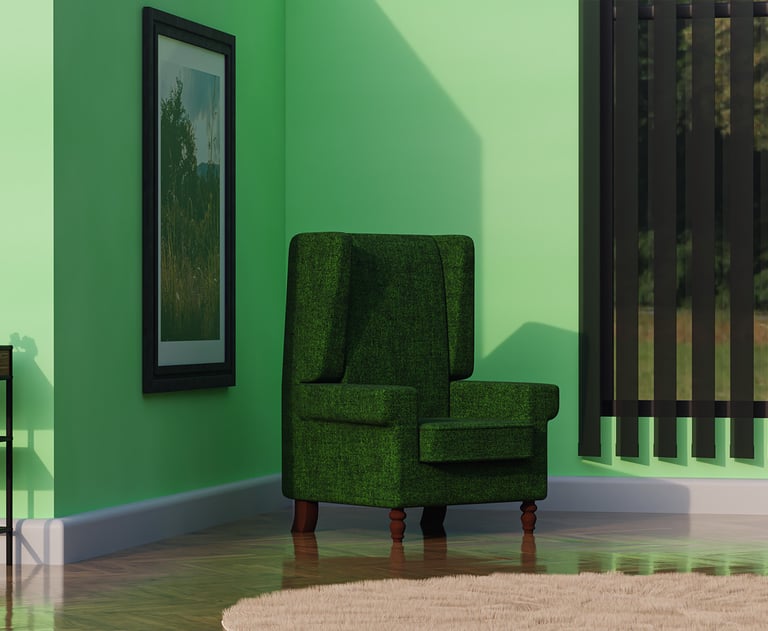 a green armchair in a green room with a table and picture