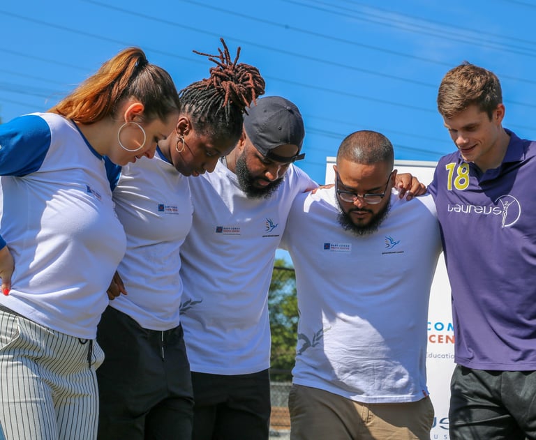 a group of people standing together outside in a huddle