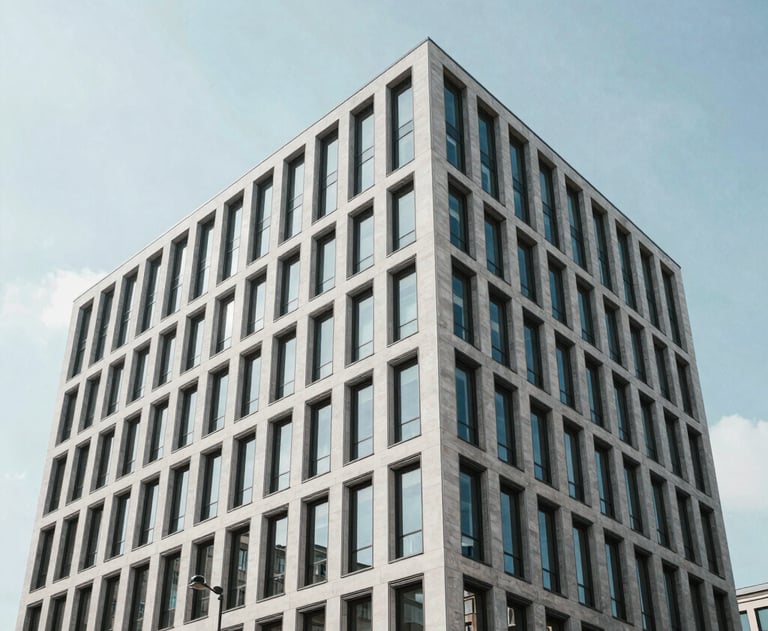 Clean, architectural shot of a modern office building in a European city like Berlin or Paris. Minimalist lines and bright sky.