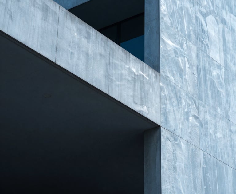 An artistic photograph of light and shadow on a modern architectural structure. The composition uses a cool palette of steel blue and pure ice, conveying stability and sophistication.