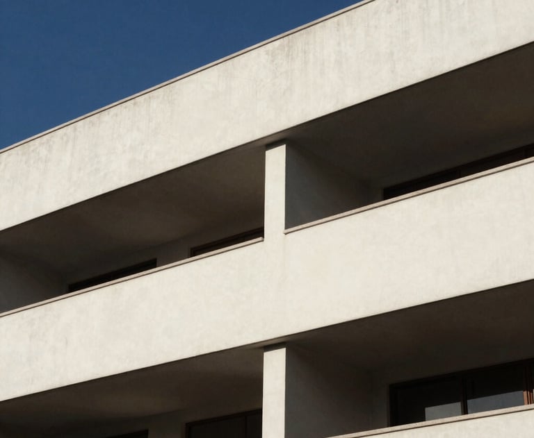Clean, artistic shot of architectural elements in a modern Latin American building. Strong shadows, off-white and deep blue tones, minimalist professional feel.