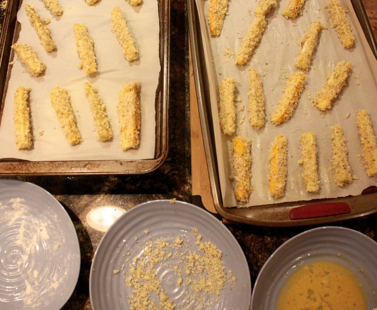 zucchini fingers ready for the oven on cookie sheets