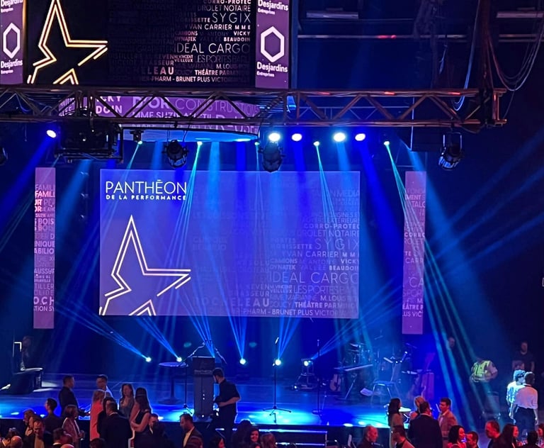 Pantheon de la Performance gala stage with blue spotlighting, corporate sponsor logos, and event signage.