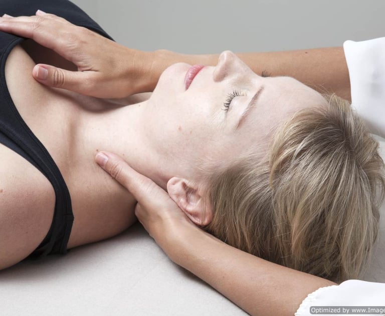 a woman lying down receiving gentle, listening touch in a craniosacral therapy session
