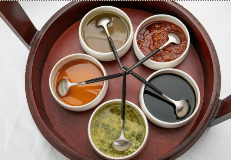 a wooden tray with sauces