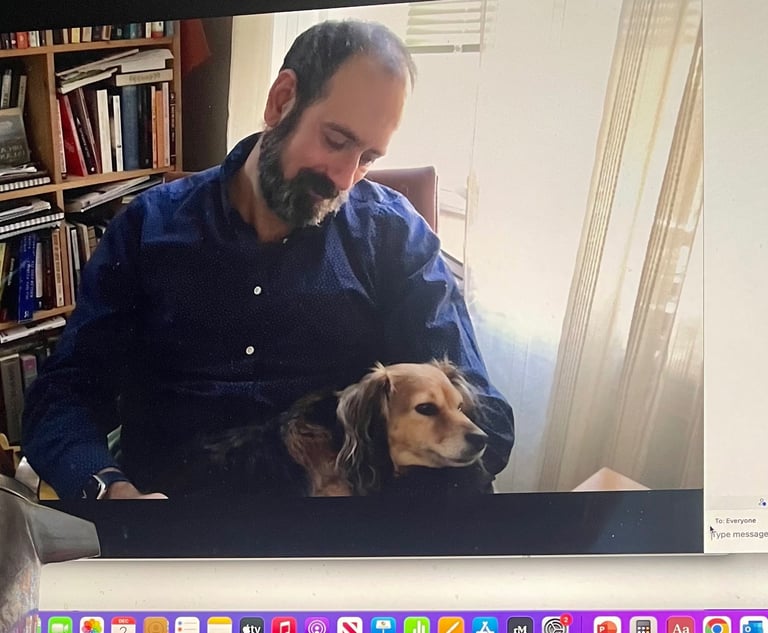 Therapist psychologist sitting on chair with small dog on his lap