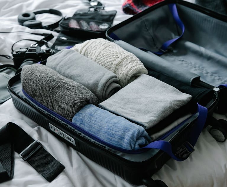 suitacase with travel camera, clothing packed for overseas travel