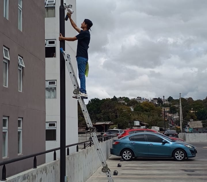técnico realizando mantenimiento a cámaras de seguridad de un condominio