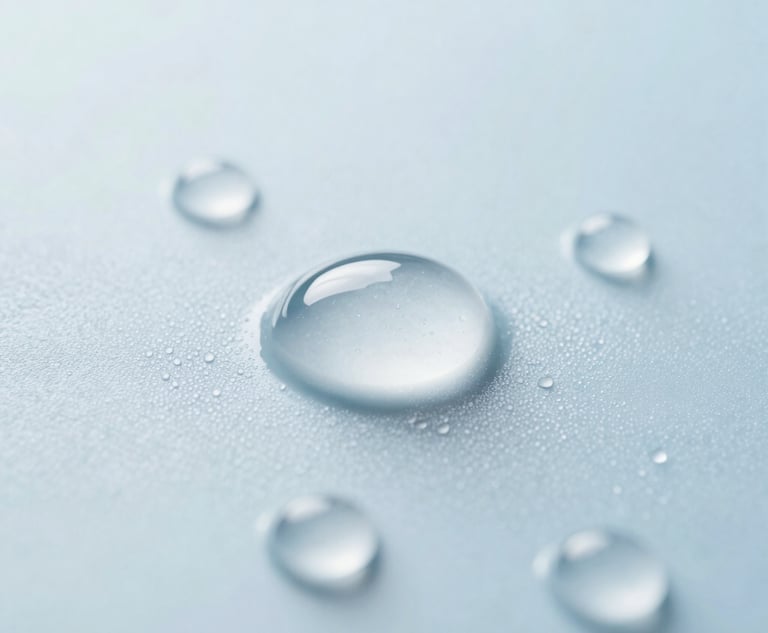 Macro photography of pure, sparkling water droplets on a smooth surface, bright clean lighting, emphasizing purity and cleanliness, pale blue and white tones.