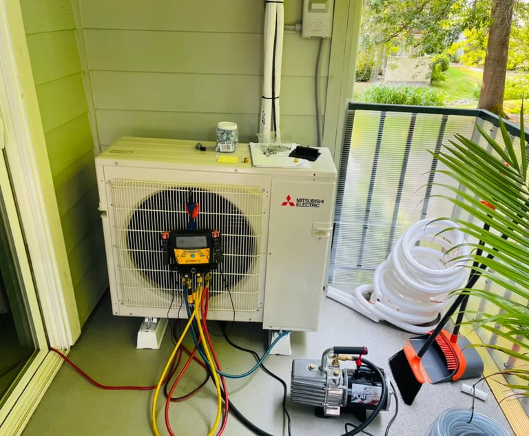 Engineer doing annual maintenance checks and readings on an Ac System on a balcony