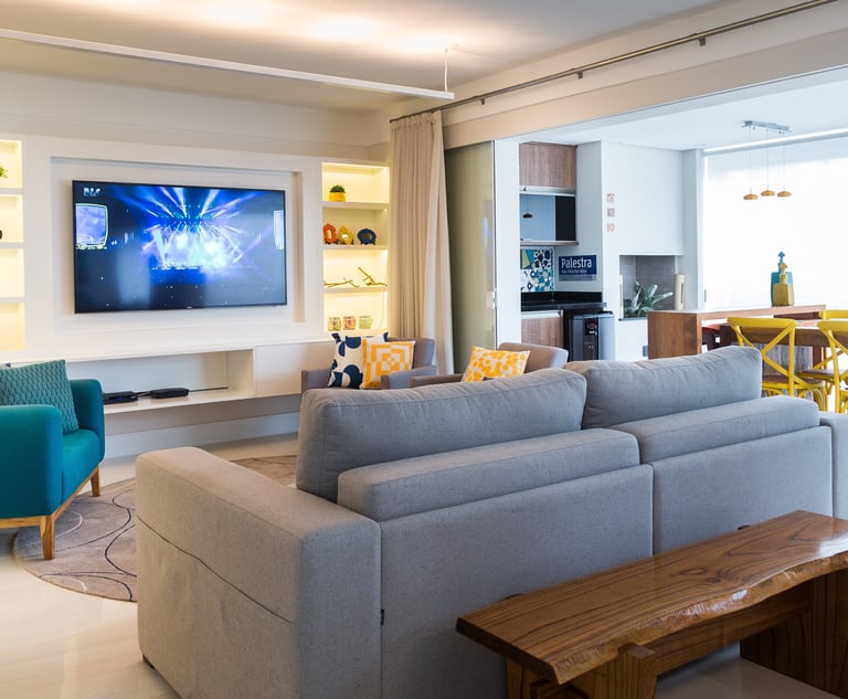 sala com televisão e sofá integrada com varanda e churrasqueira
