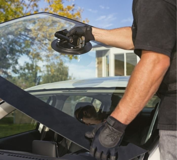 a man in a black shirt is holding a WINDSHIELD