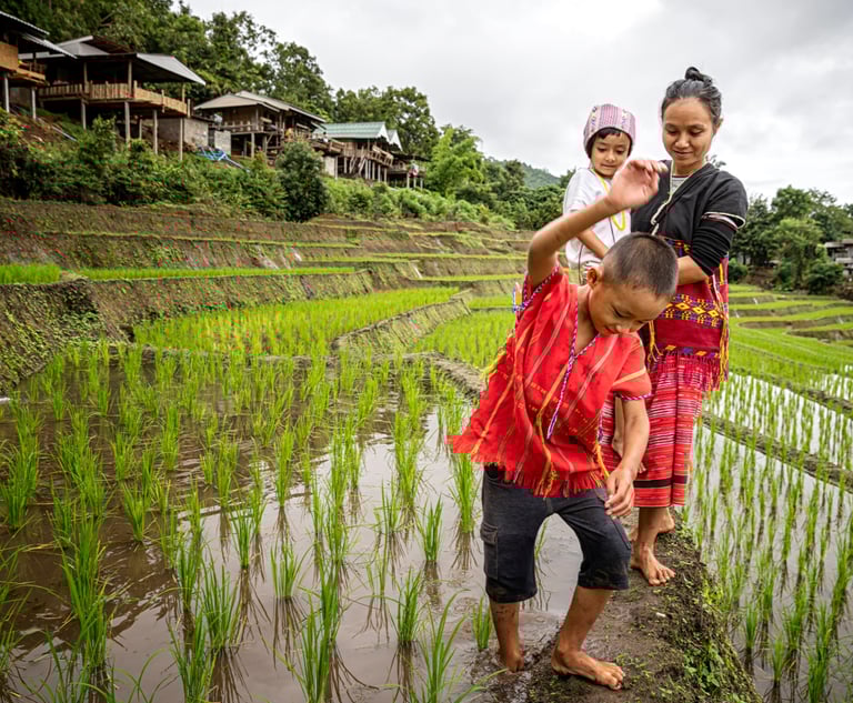 a woman and two children standing in a field