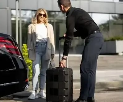 a man and woman standing in front of a car