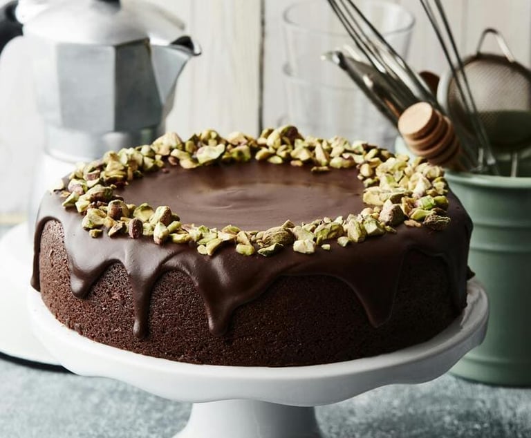 Torta de chocolate húmeda, cubierta con ganache de chocolate oscuro y pistachos