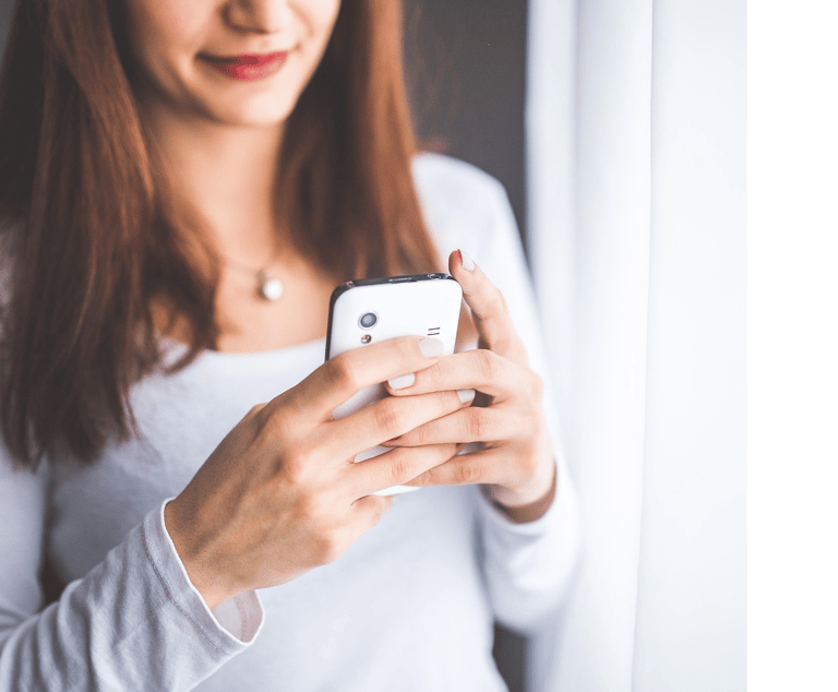 Mulher com celular na mão chamando conserto da geladeira