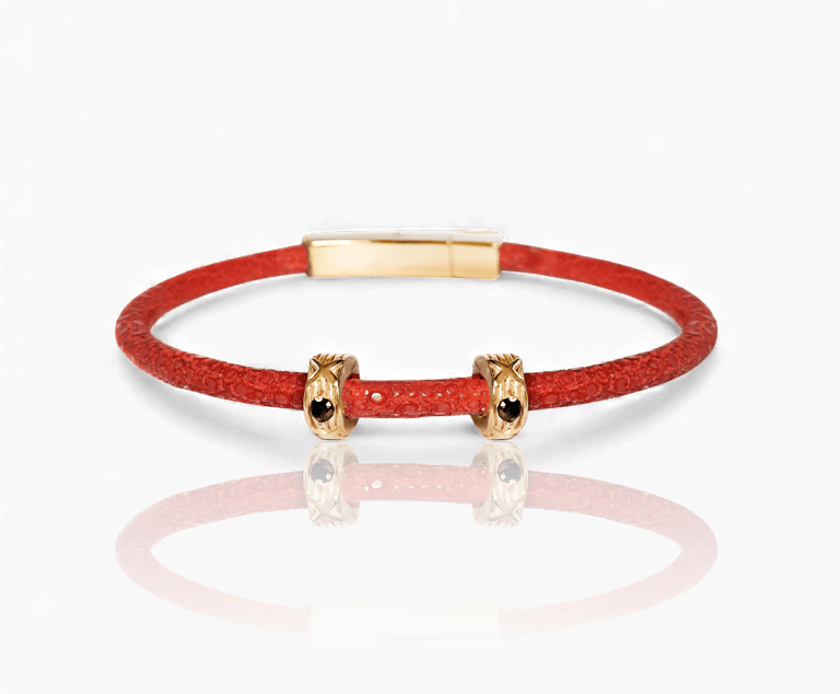 Red stingray leather bracelet featuring gold charms with black crystals.
