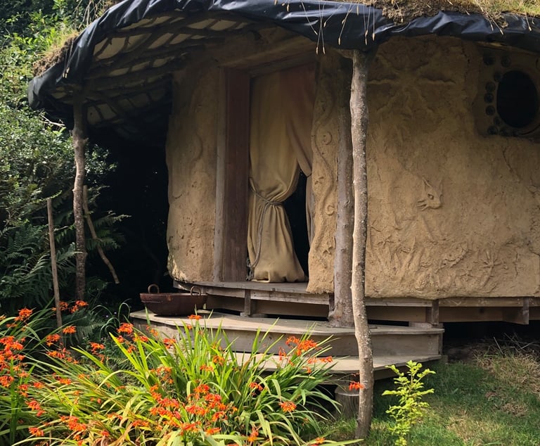 cob round house set in a wild garden