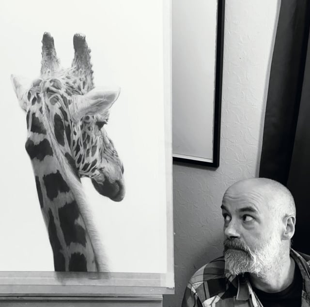 A photo of Will Arden with a drawing of a giraffe