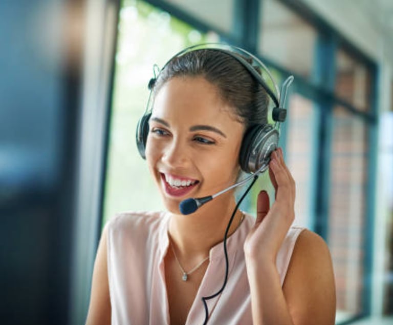 a woman in a pink shirt and headphones with a headset