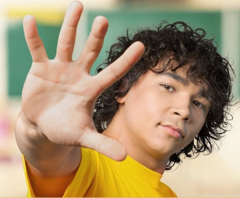 a kid with curly hair and a yellow shirt