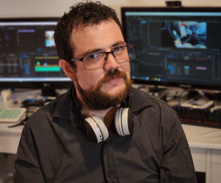 a man with a beard and headphones on a desk