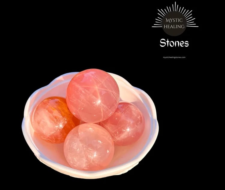 Polished pink rose quartz crystal spheres in a white bowl for healing and meditation.