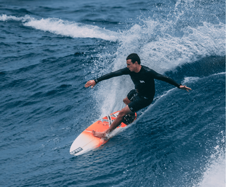 a man in a wetsuit surfing on a surfboard