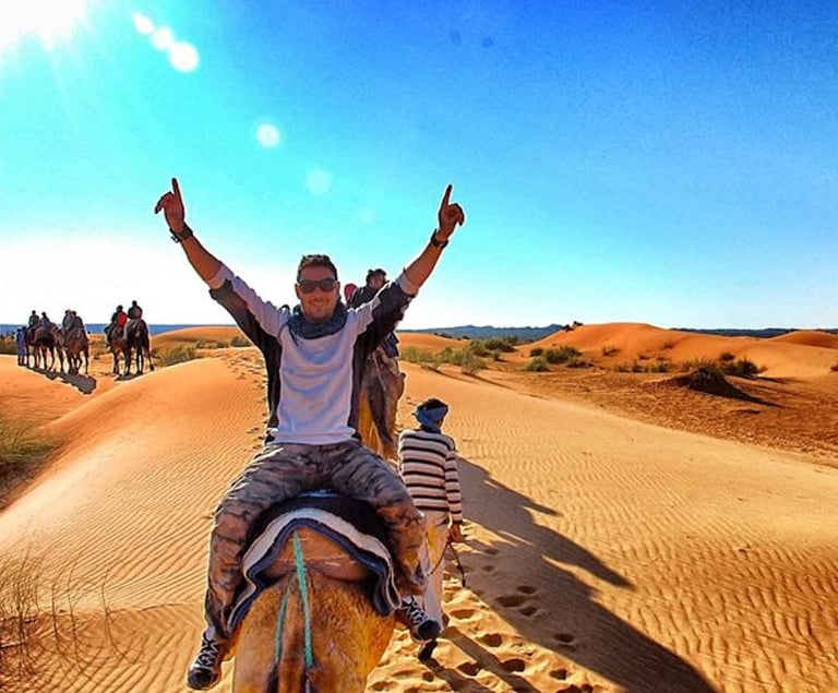 a man riding a camel in the desert