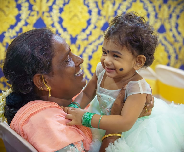 A mother sharing a joyful candid moment with her baby at an event photographed by Memories and More 