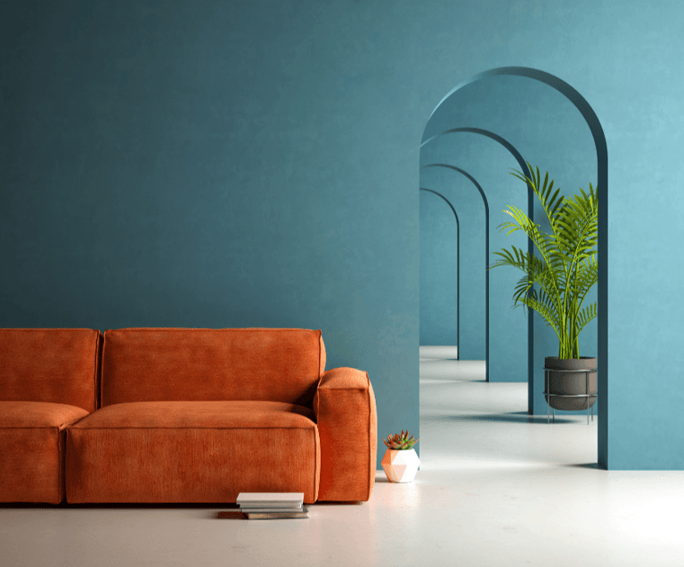 Modern living room with orange velvet sofa against a teal wall and arched hallway.