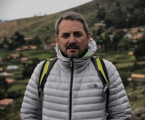 a man in a grey jacket and a backpacker