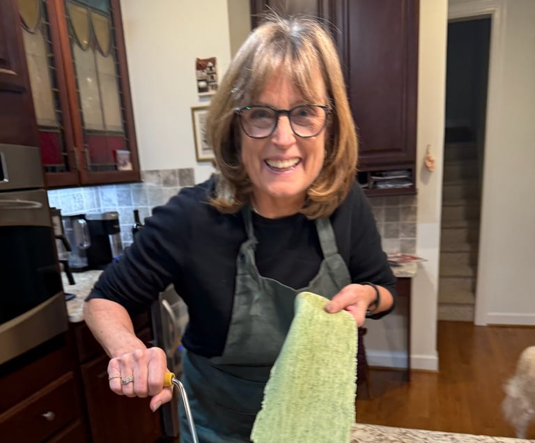 Class participant hand rolling spinach pasta noodle