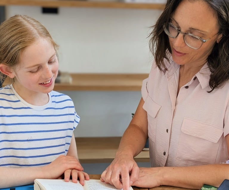 A Kent tutor and primary school girl reading a book together during an 11+ tutoring session