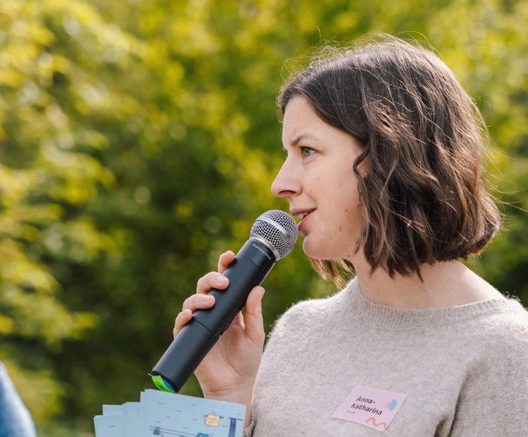 Moderatorin Anna-Katharina Pelzel in aktiver Interaktion mit der Gruppe – lebendig und präsent