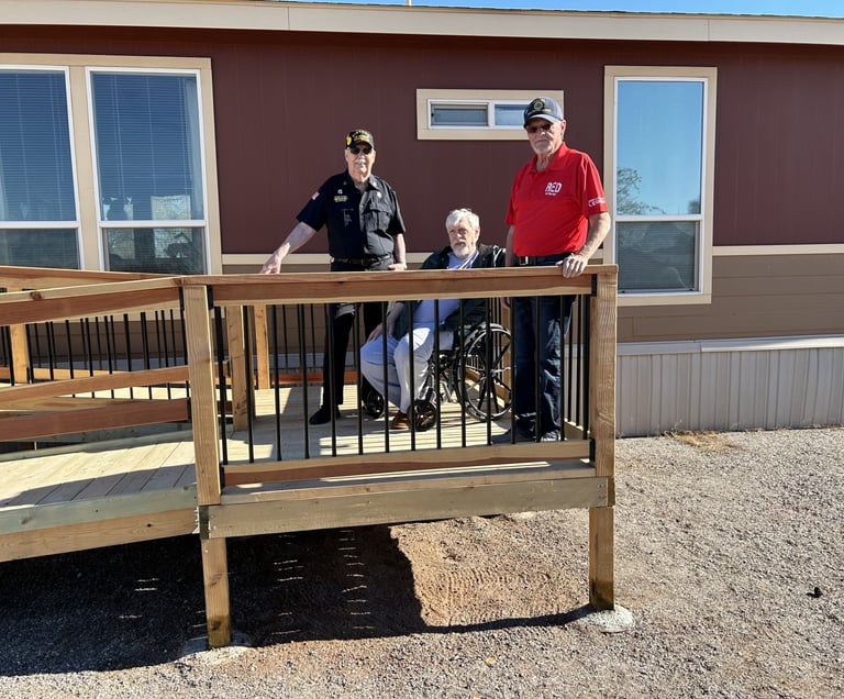 Image shows three gentlemen on a freshly constructed wheelchair ramp