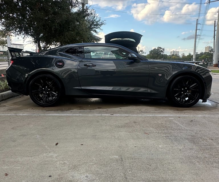 Side profile of a dark gray Chevrolet Camaro sports car after a hand wash and detail