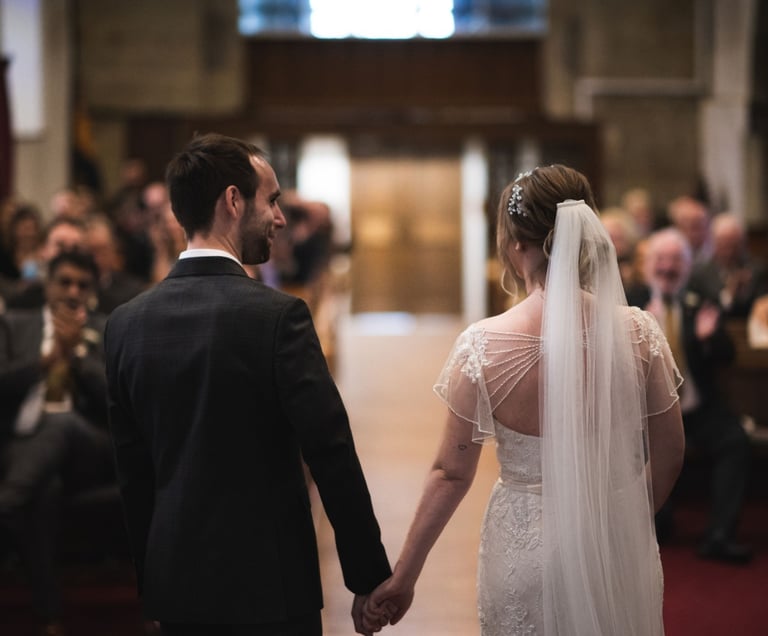 a bride and groom holding hands in a church
