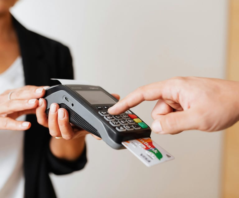 Customer entering PIN on a credit card machine for a secure retail payment transaction.