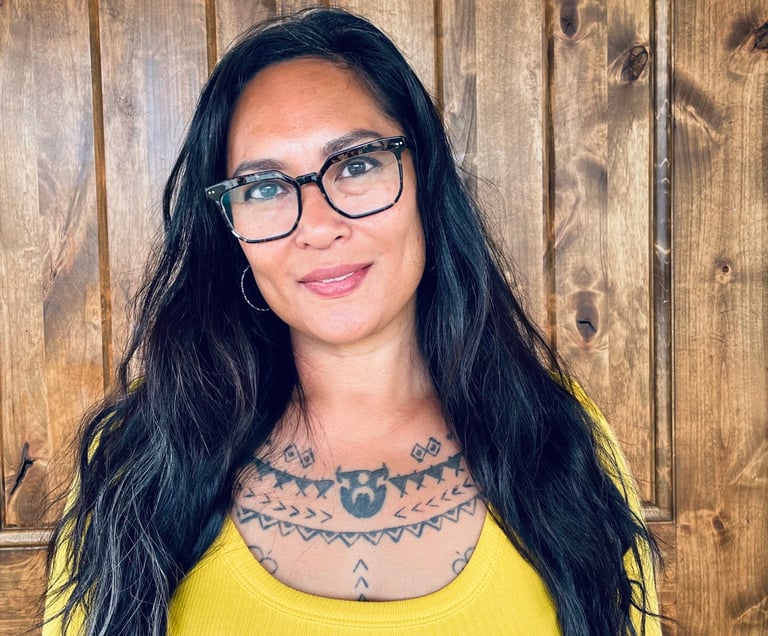 Portrait of death midwife Michelle Mondia in front of wood wall.