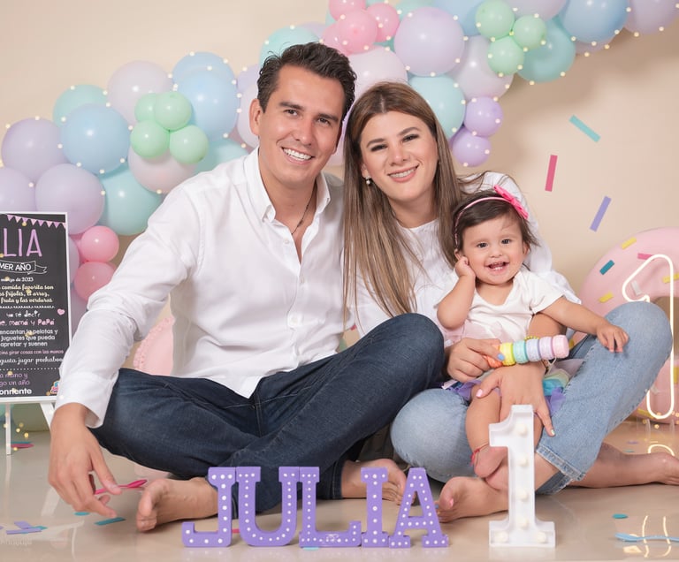 a man and woman sitting on a floor with balloons