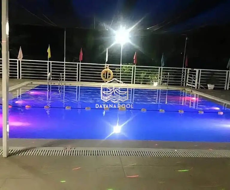 Pemandangan kolam renang yang tenang di malam hari, menciptakan suasana oase di perkotaan.