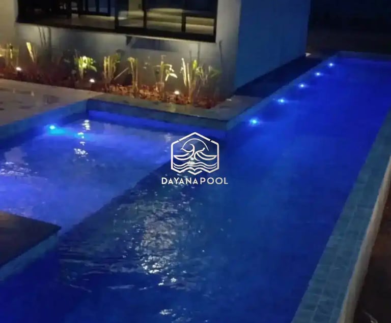 Pemandangan kolam renang yang tenang di malam hari, menciptakan suasana oase di perkotaan.