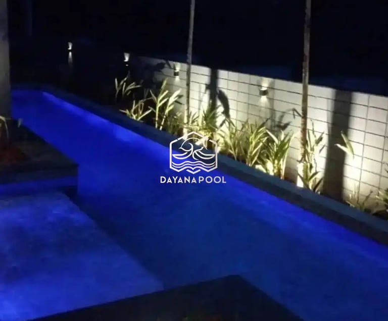 Pemandangan kolam renang yang tenang di malam hari, menciptakan suasana oase di perkotaan.