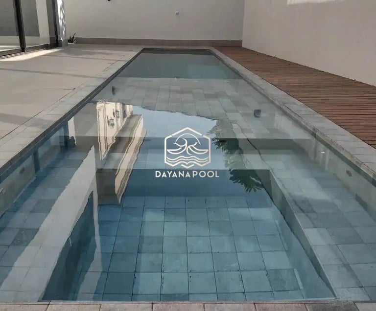 Desain kolam renang minimalis modern dengan air jernih di halaman belakang rumah
