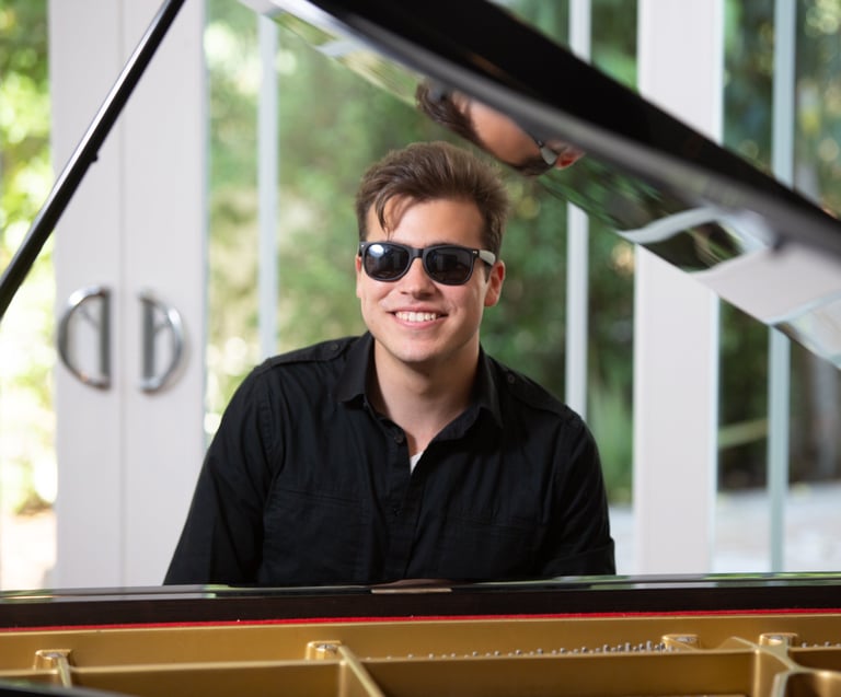 Daine Jordan on the piano with sunglasses
