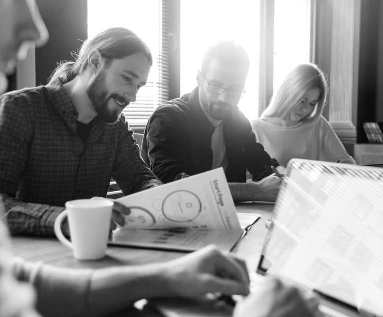 a man and woman sitting at a table with a laptop