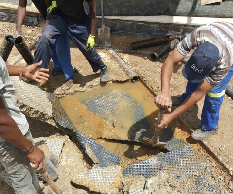 Engineers inspecting damaged concrete slab for water ingress
